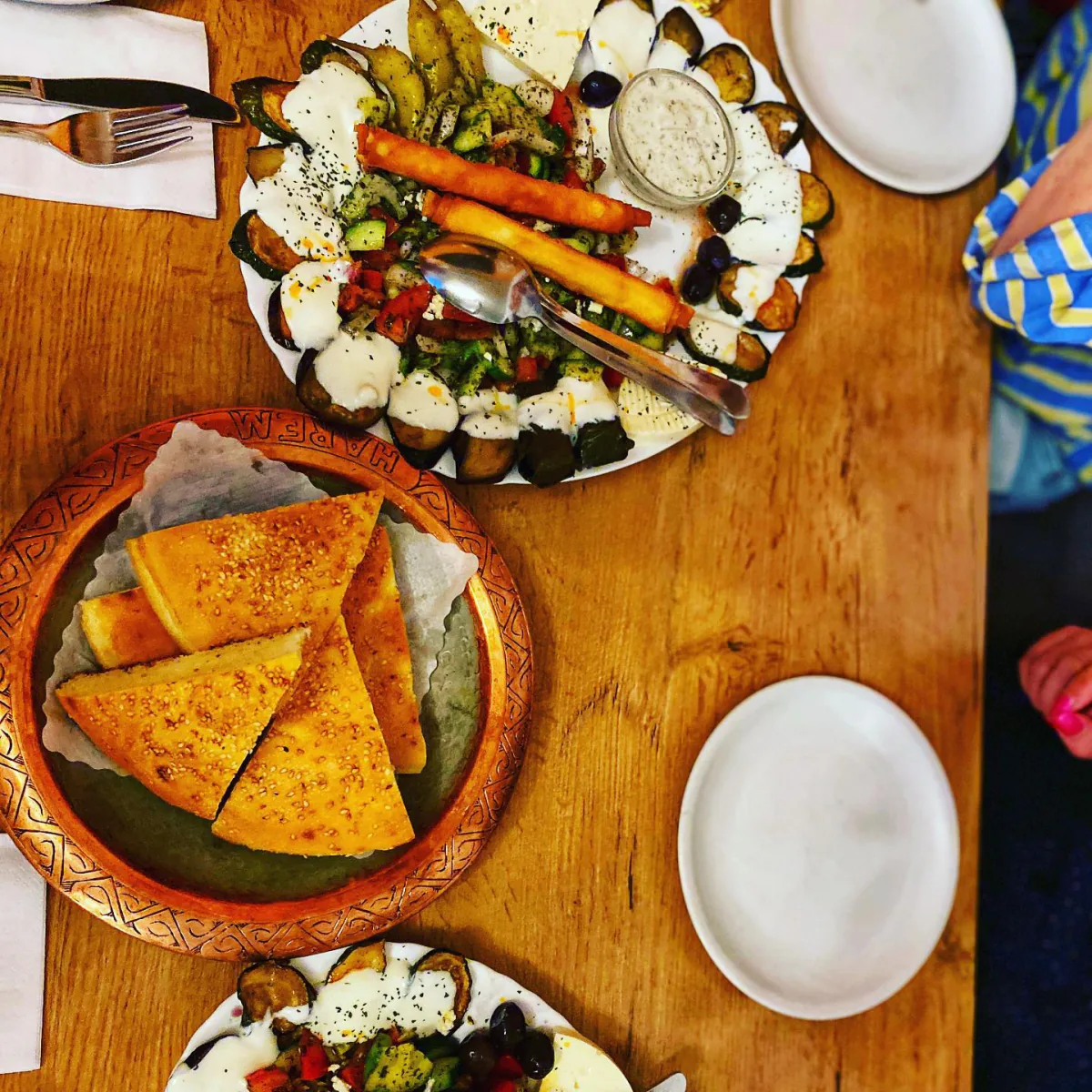 Gedeckter Tisch mit Börek auf Tonteller und Meze-Platten